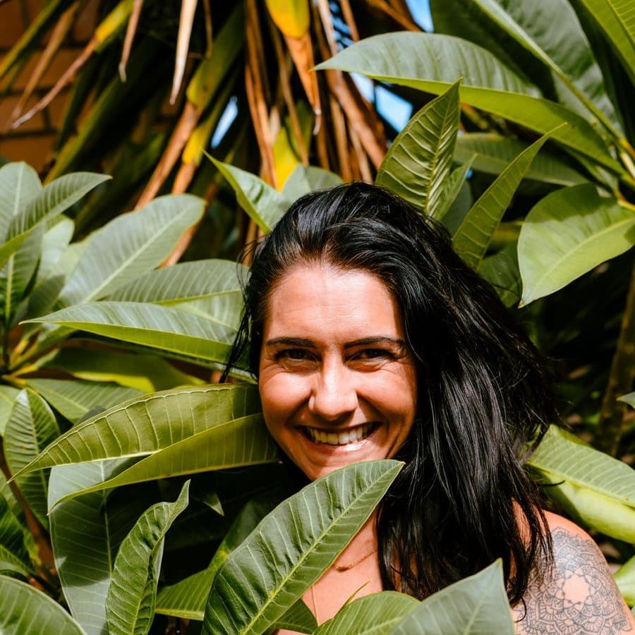 Kati Ackerman smiling among broad green leaves