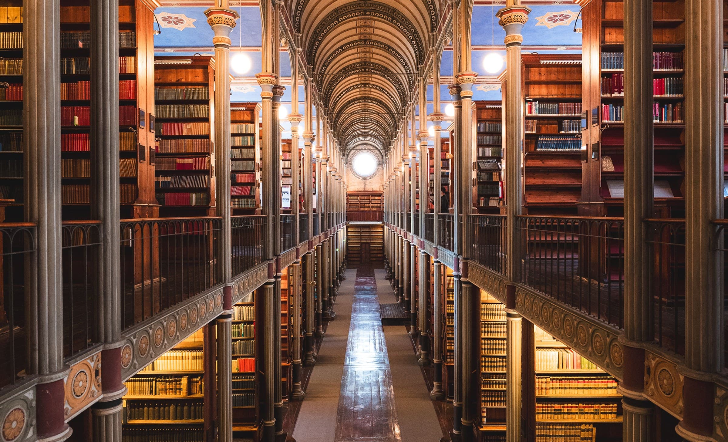 The nave of a vaulted library, its shelves running the length of the hall