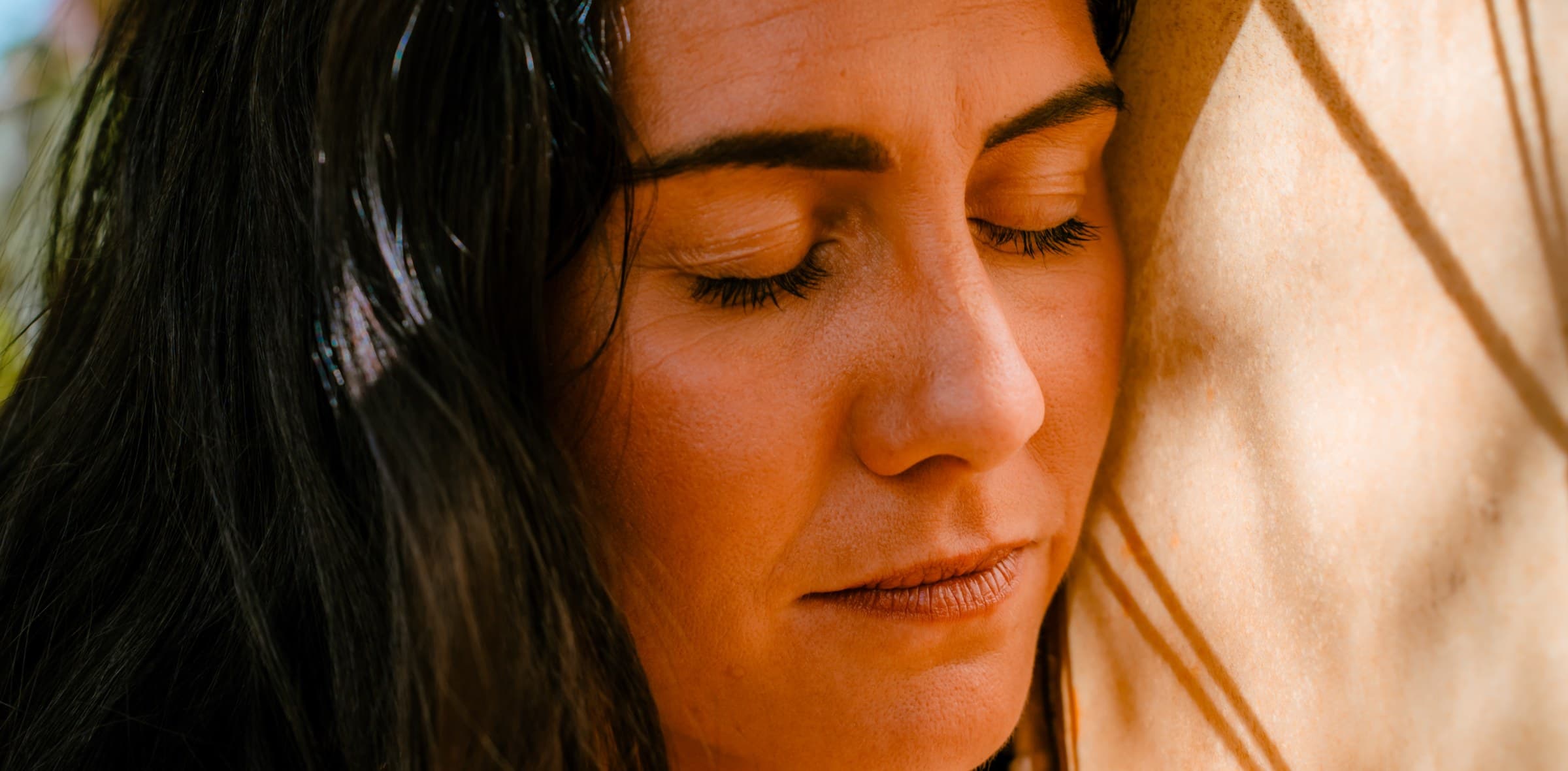 Kati with her eyes closed, her face turned into warm light
